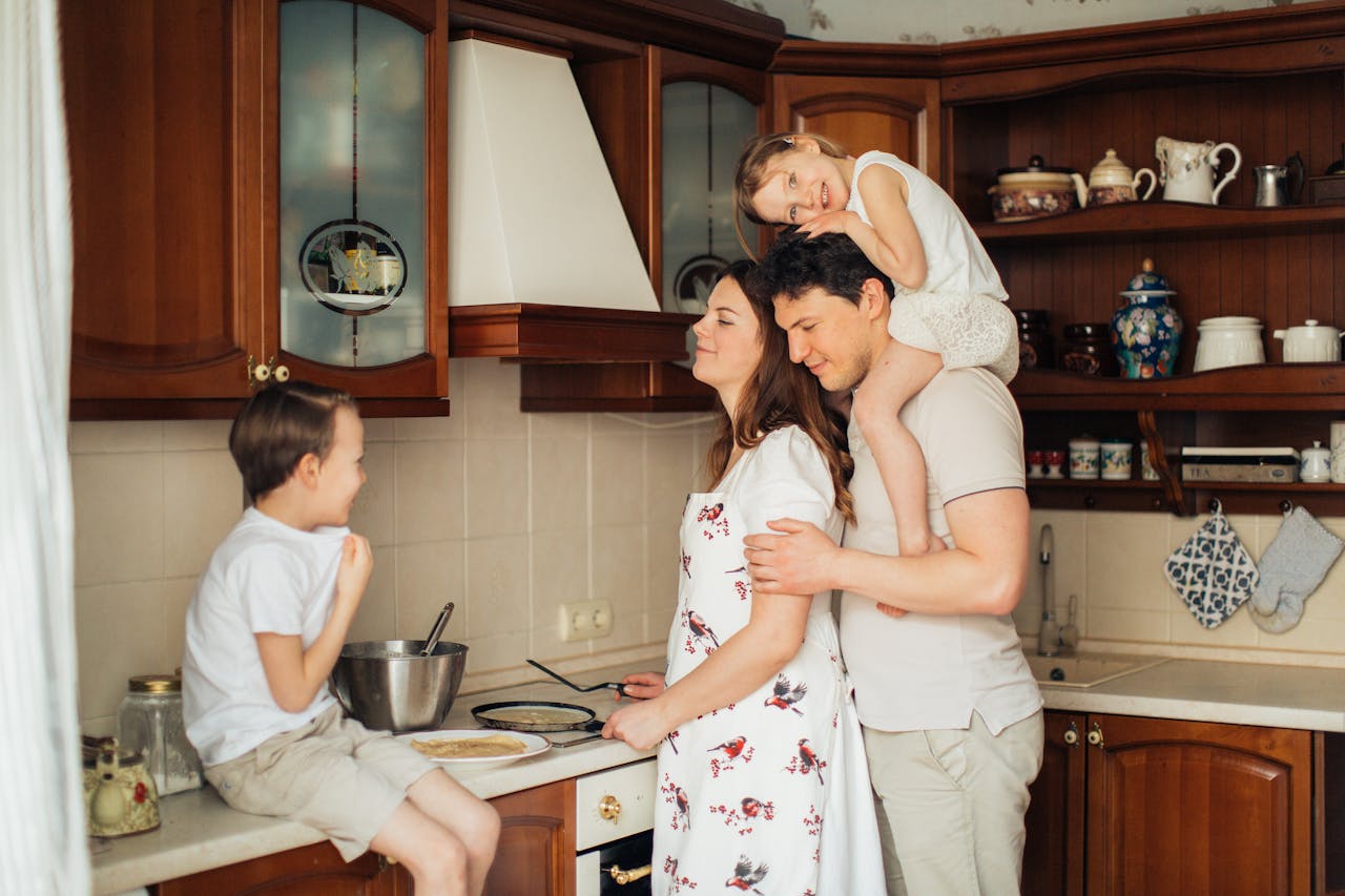 A joyful family moment as parents and children cook together in a cozy kitchen setting.